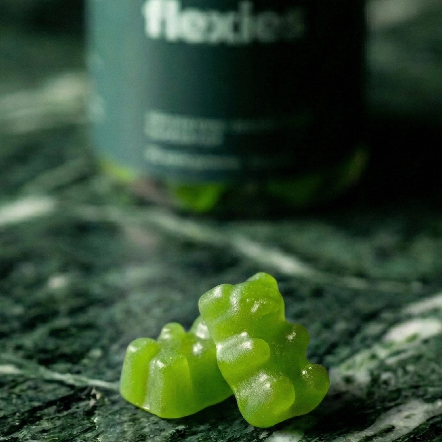 Close-up of green sea moss gummies with bottle in background